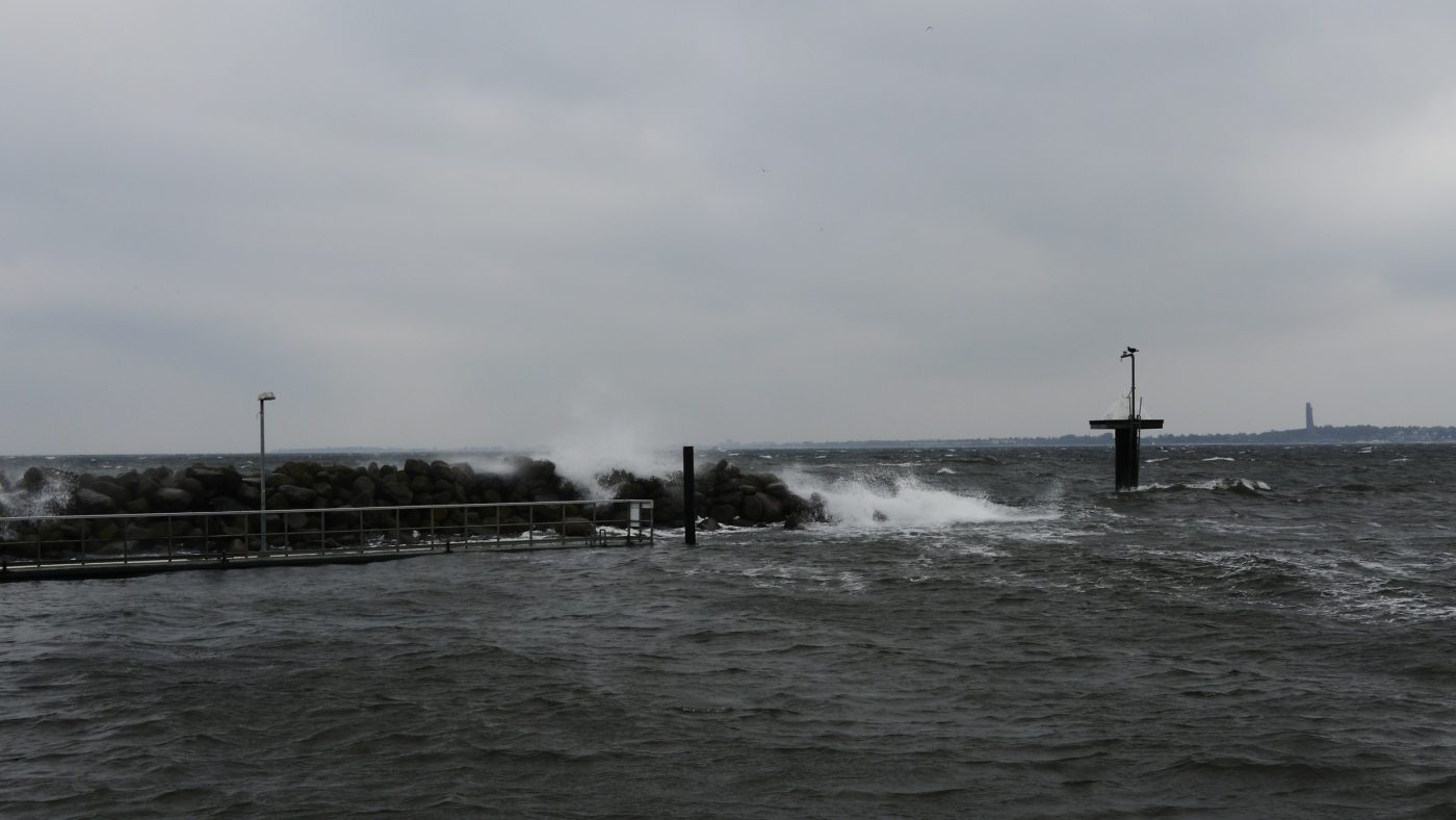 Wellen brechen an einer Mole