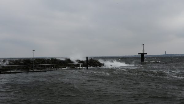 Wellen brechen an einer Mole