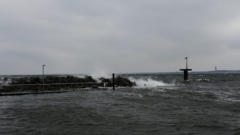 Wellen brechen an einer Mole