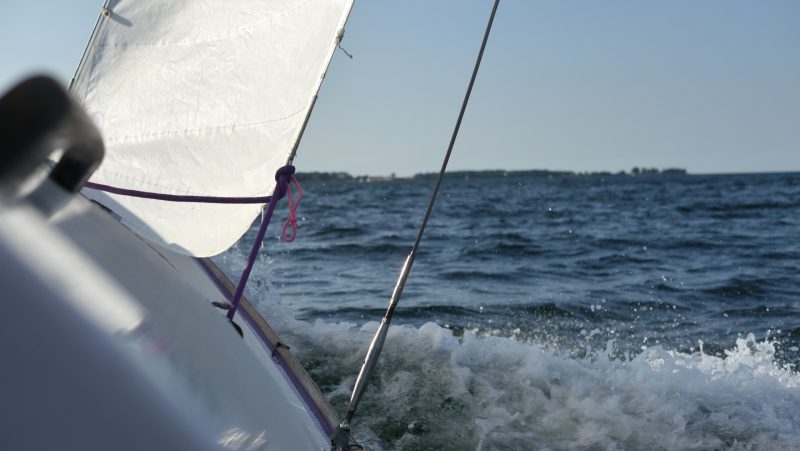 Wellen brechen am Bug eines Folkeboots